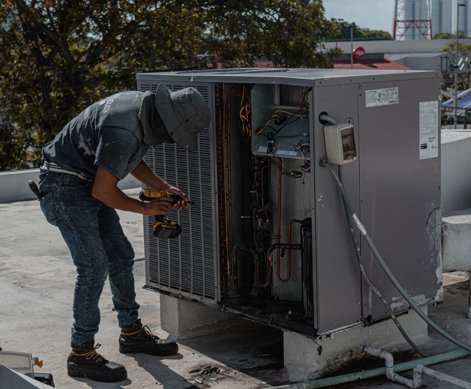 Technician working inside an outdoor air conditioning unit