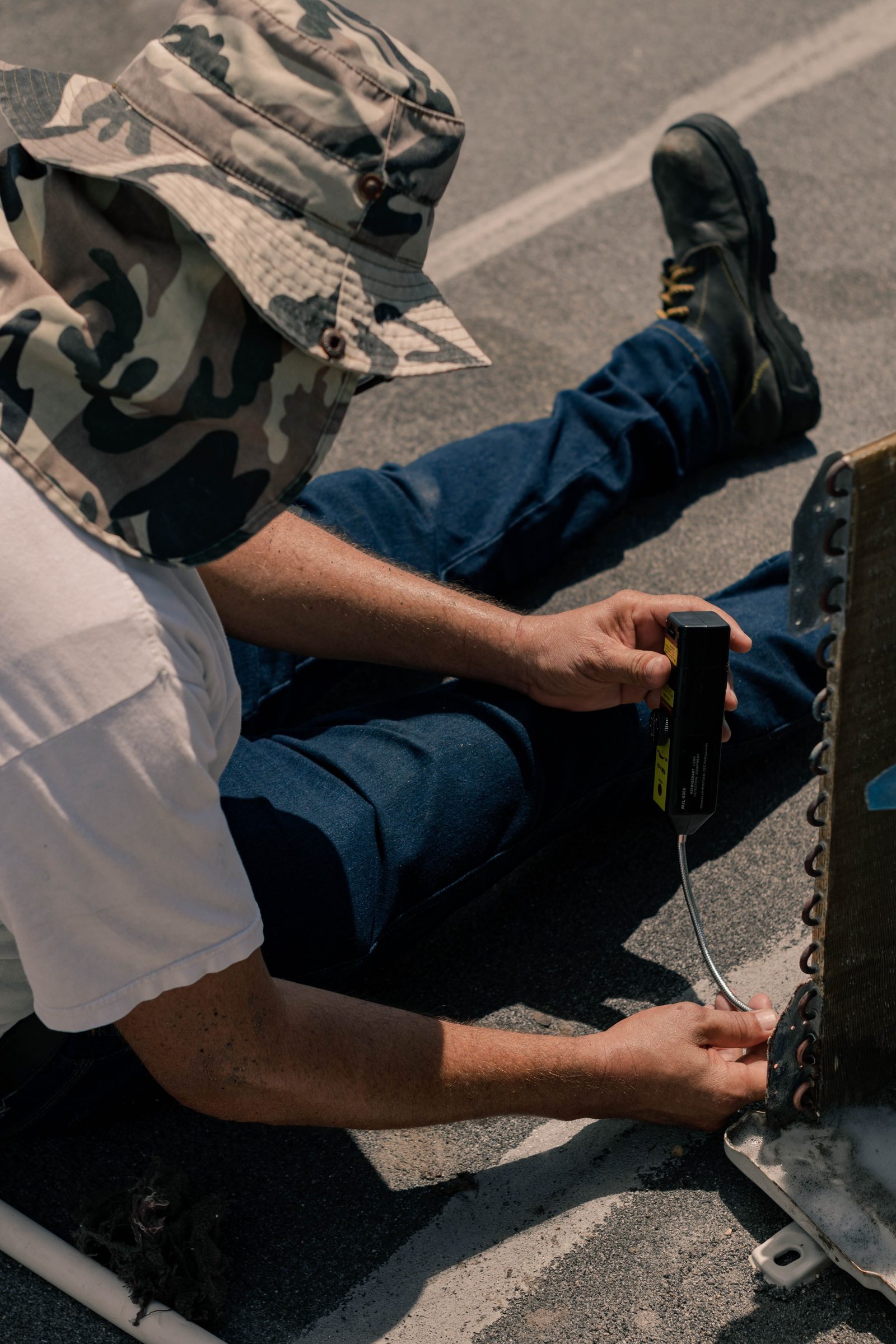 Technician working on the side of an outdoor AC unit